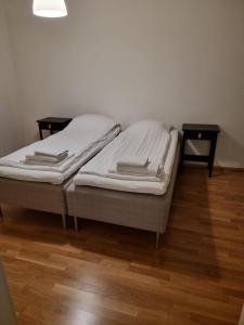 a bed sitting on top of a wooden floor at Kotimaailma Saunallinen kaksio keskustan tuntumassa in Vaasa
