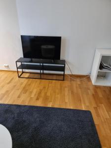 a living room with a flat screen tv and a wooden floor at Kotimaailma Saunallinen kaksio keskustan tuntumassa in Vaasa