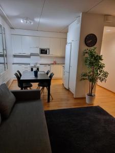 a living room with a table and a kitchen at Kotimaailma Saunallinen kaksio keskustan tuntumassa in Vaasa