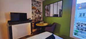 a living room with a small table and a television at La cachette de la Reine in Fontainebleau