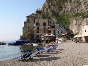 a group of chairs on a beach with a building at Casa Console in Conca dei Marini