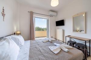 a bedroom with a large bed with two towels on it at Lotus Apartment 1 in Corfu