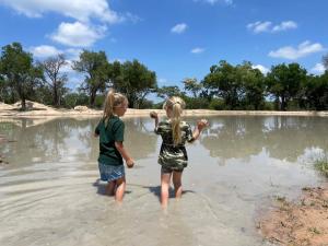 two little girls standing in the water on the beach at Ukujabula in Groblersdal +9 photos