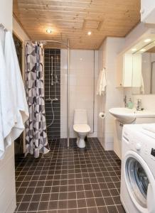 a bathroom with a toilet and a shower and a sink at Kotimaailma Two bedroom apartment with private sauna in Vaasa