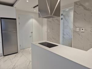 a kitchen with a white counter and a refrigerator at 펜톤나인 해변열차 송정2호점 in Busan +65 photos
