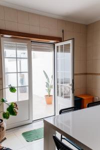 a kitchen with sliding doors and a table and chairs at Green House in Baleal