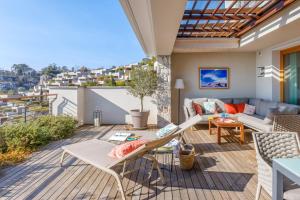 eine Terrasse mit einer Couch und einem Tisch in der Unterkunft Portopiccolo Apartments - Telgatino nel Golfo in Sistiana