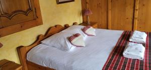 ein Schlafzimmer mit einem Bett mit weißen Decken und Kissen in der Unterkunft Chambres Gambrinus in Beblenheim