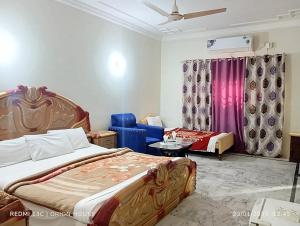 una habitación de hotel con una cama y un sofá en Orion International Guest House, en Islamabad