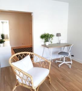a wicker chair in a living room with a table at Kotimaailma Family apartmen in the city center close to the beach in Vaasa