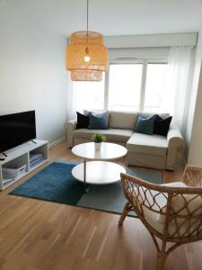 a living room with a couch and a table at Kotimaailma Family apartmen in the city center close to the beach in Vaasa
