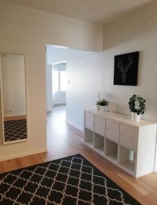 a living room with a white room with a mirror at Kotimaailma Family apartmen in the city center close to the beach in Vaasa +1 photo