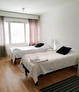 a bedroom with two beds and a window at Kotimaailma Family apartmen in the city center close to the beach in Vaasa