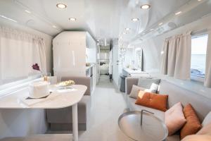 a white room with a table and a couch at Daydream - אוטובוס-צימר בגשר הזיו in Gesher HaZiw