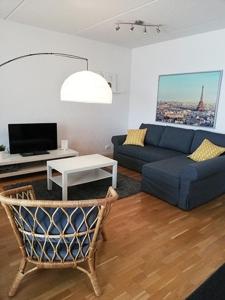 a living room with a blue couch and a table at Kotimaailma Two bedroom apartment with private sauna in Vaasa