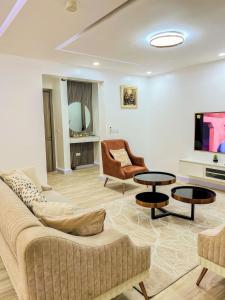 sala de estar con sofá, silla y mesas en Luxurious 2-Bedroom Apartment in Lagos with City View, en Lagos 15 fotos más