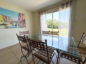 PréchacVilla Sheila - Au bord de l'eau avec piscine的配有玻璃桌椅的餐厅