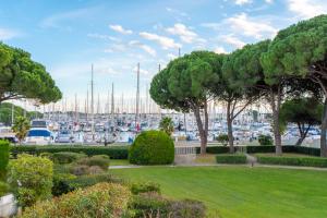 a park with trees and a marina with boats at Le Cormoran Air-Climatisé-Parking-Vue Marina-Plage in Le Grau-du-Roi