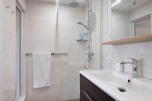 a white bathroom with a sink and a shower at Sonnige Ferienwohnung im Kinzigtal in Wolfach +27 photos