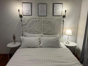 a bedroom with a bed with a metal headboard and two tables at 3 bedrooms 2 bathroom's in Bang Su