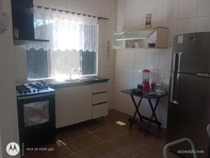 a small kitchen with a sink and a refrigerator at Casa de Praia in Pontal do Paraná +4 photos
