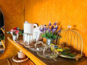 a wooden table with dishes and flowers on it at Libong Luxury Beach in Trang