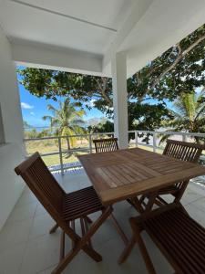 a wooden table and chairs on a porch at Paisible oasis in Case Noyale