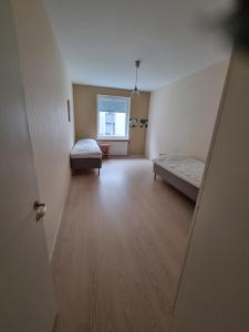 an empty room with two beds and a window at Kotimaailma 1 bedroom apartment in city center in Vaasa