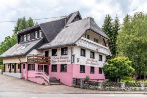 a pink and white building with a black roof at pop-up stuub feldberg in Feldberg