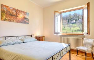 a bedroom with a bed and a window and a chair at Casa Lilly in Varese Ligure
