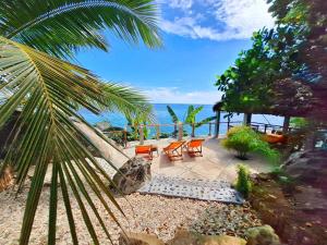 un patio con sedie e vista sull'oceano di Villa c'est la vie a Nosy Komba