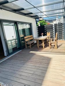 a patio with benches and a table on a deck at Parkblick in Thale