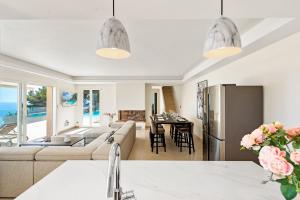 a kitchen and living room with a couch and a refrigerator at L Oasis Moderne piscine vue mer in Roquebrune-Cap-Martin