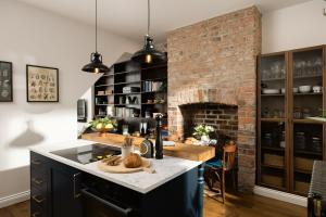 a kitchen with a brick wall and a fireplace at The Residence, Luxury City Stay in York