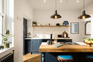 a kitchen with blue cabinets and a wooden table at The Residence, Luxury City Stay in York