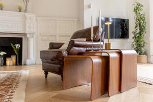 a living room with a leather chair and a suitcase at Hôtel particulier - Le 119 in Valenciennes +144 photos