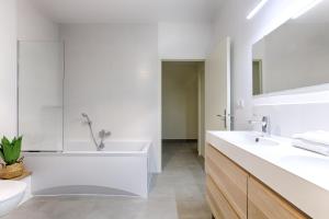 un bagno bianco con vasca e lavandino di Villa Nature à 10 Minutes de Disneyland Paris a Chalifert Altre 47 foto