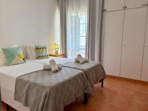 ein Schlafzimmer mit einem großen Bett mit zwei Handtüchern darauf in der Unterkunft Beach Relax Apartment in Porto Santo