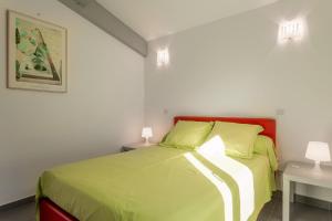 a bedroom with a bed with green sheets and two tables at Villa les Mimosas in Bormes-les-Mimosas