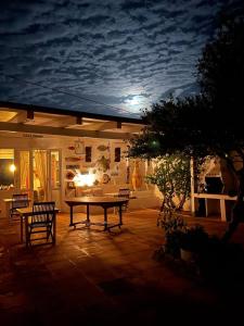a patio at night with a table and chairs at B&B Cala Pisana (Paola e Melo) in Lampedusa