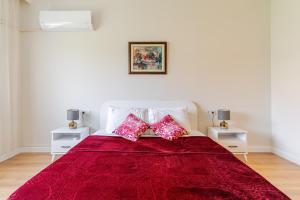イズミールにあるComfortable and new apartment near the sea!の赤いベッドと2つの白いナイトスタンドがある寝室