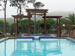 Kiddʼs BeachPalm Springs Holiday Beach Resort的一个带凉亭和泳池景的游泳池