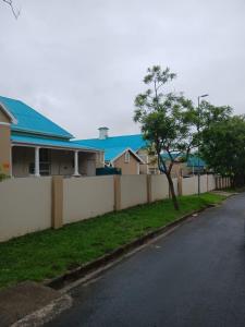 Kiddʼs BeachPalm Springs Holiday Beach Resort的街道旁的房屋,有栅栏和树