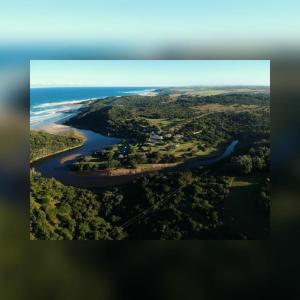 Kiddʼs BeachPalm Springs Holiday Beach Resort的享有河流和海洋的空中景致