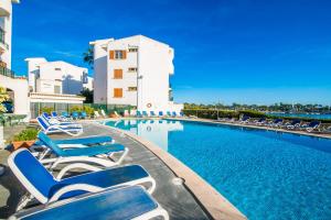 a swimming pool with lounge chairs and a building at Ideal Property Mallorca - Dali 127 in Port d'Alcudia