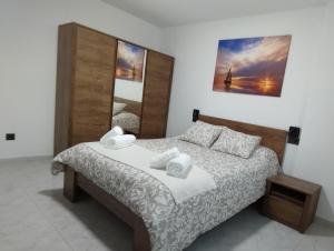 a bedroom with a bed with two towels at Apartamento REYSAR in Muxia