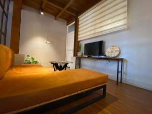 Un dormitorio con una cama, un televisor y una mesa. en Charming Industrial studio apartment, en Katmandú