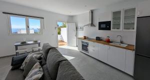 a living room with a couch and a kitchen at Casa Sol. Tu refugio de relax en Lanzarote in Tías