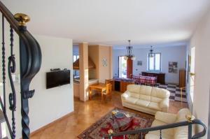 a living room with a white couch and a kitchen at - Luxury Villa Lunigiana Private Swimming Pool- in Bagnone