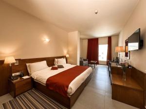 una camera d'albergo con un letto e una televisione di Cosmopolitan Hotel a Beirut